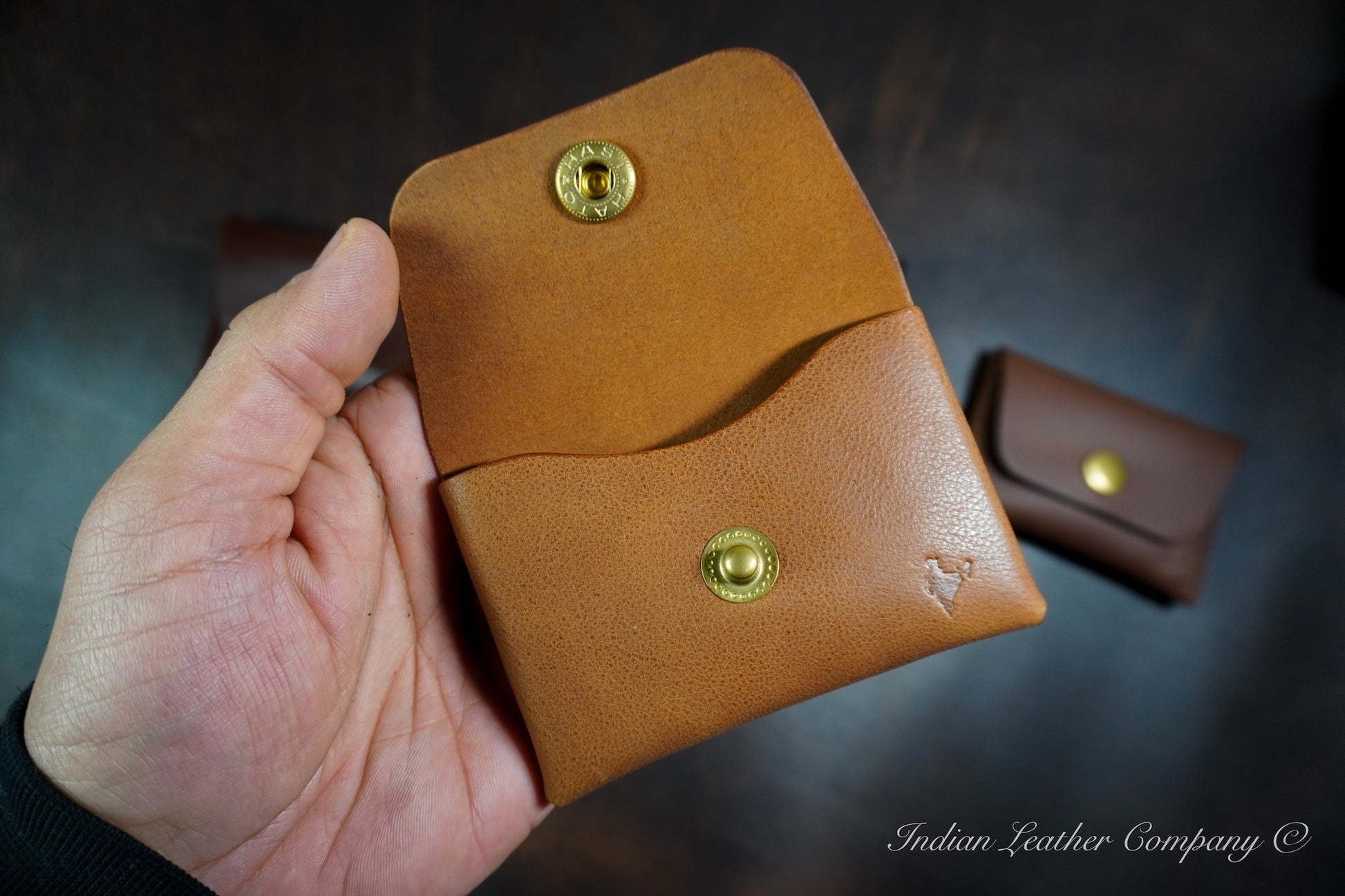 Handmade minimalist leather snap wallet designed for everyday carry, shown held in hand