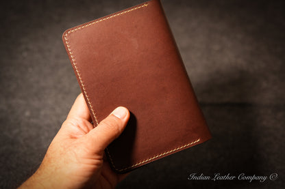 Back view of black leather A6 journal cover showing red saddle stitching along the edges