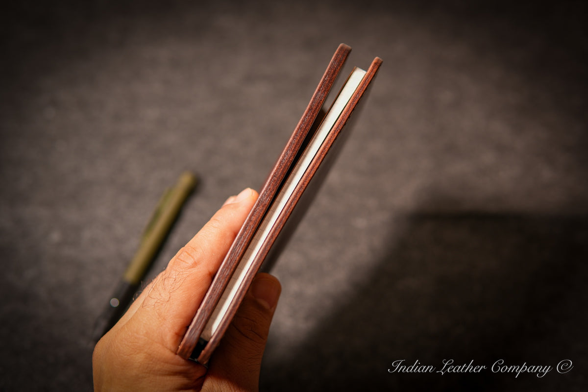 Side profile showing slim thickness of A6 leather journal cover with notebook and cards inside