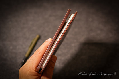 Side profile showing slim thickness of A6 leather journal cover with notebook and cards inside